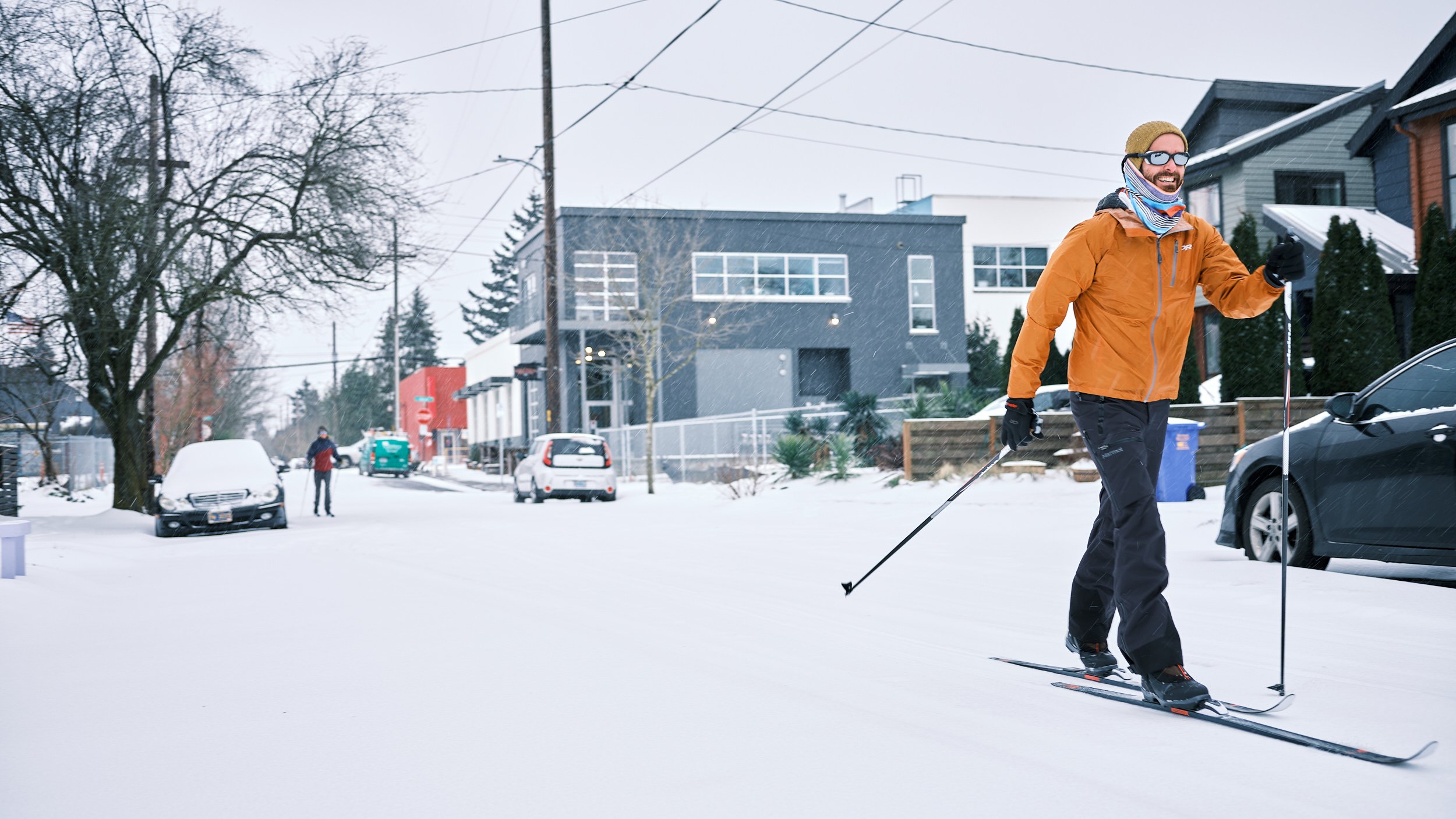 Cross country skiers making their way down a snowed in city street.