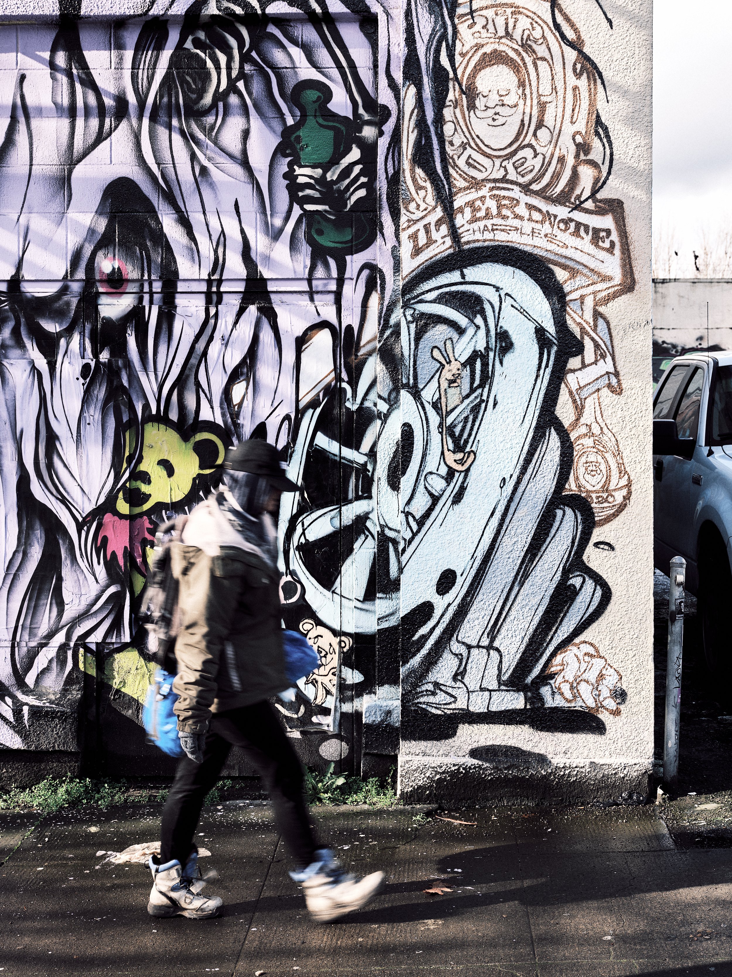 A person walking on a sidewalk in front of a freshly painted street mural.