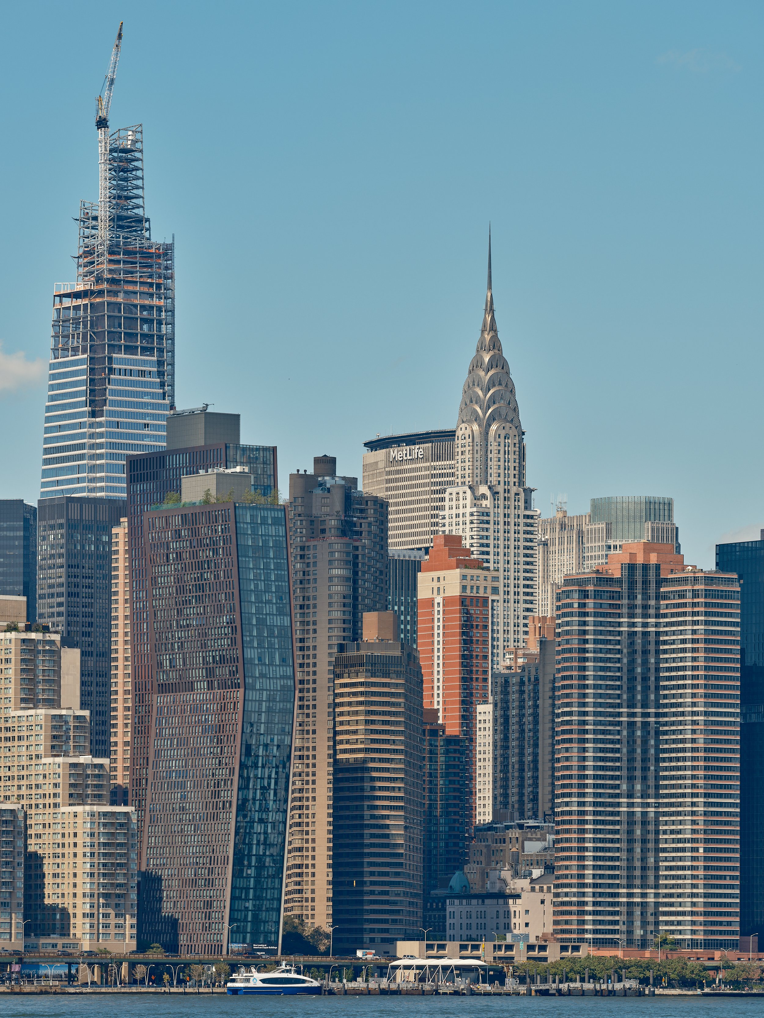 A slice of New York City's Manhattan skyline with One Vanderbilt building under construction on a sunny summer afternoon.
