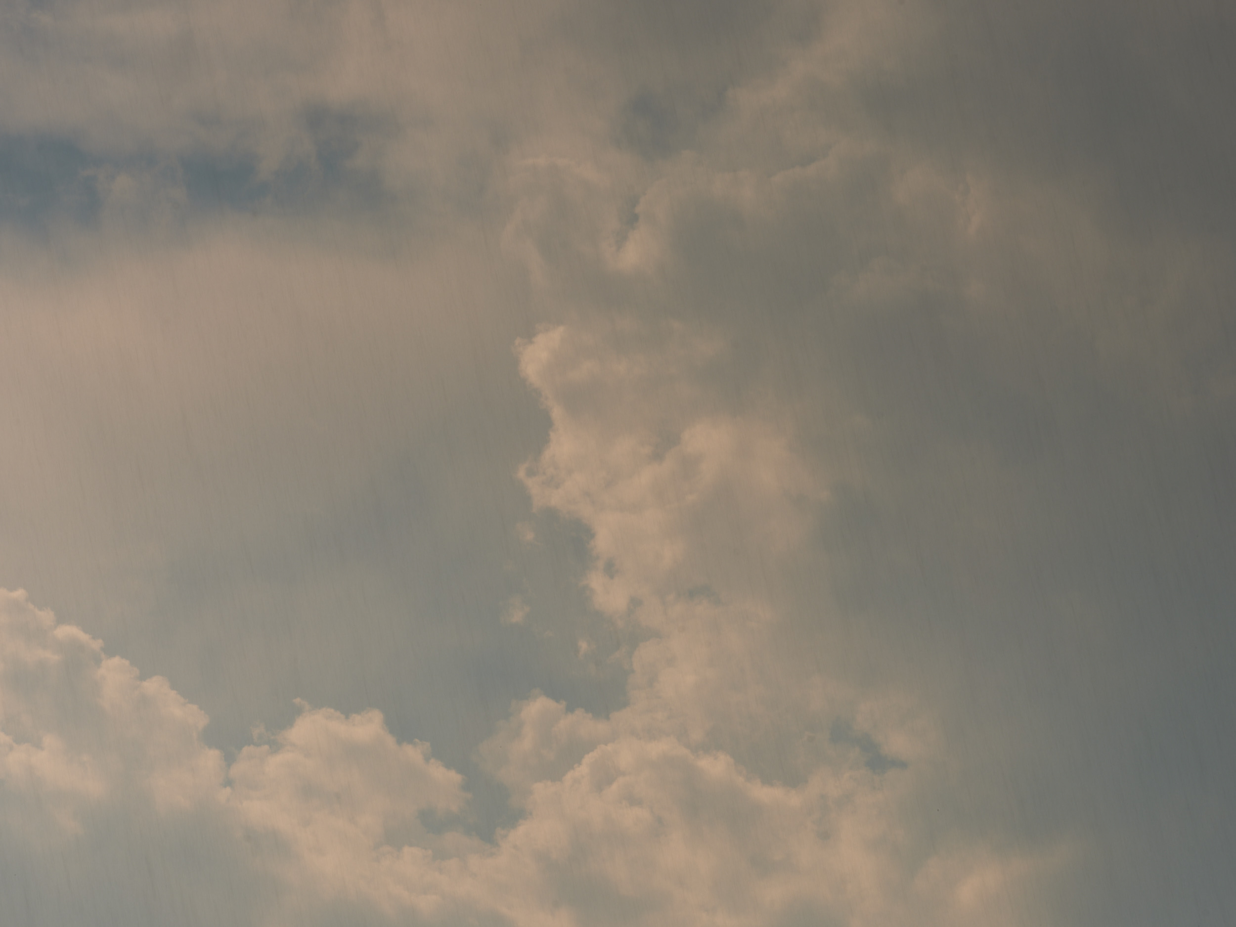 A moody sky filled with thick, billowing clouds in various shades of gray and white, captured over Portland, Oregon. The atmospheric conditions create a dramatic overcast scene with layers of cumulus clouds against a muted sky.